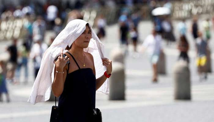 A woman walks in Vatican City during a heatwave across Italy, July 19, 2023. — Reuters