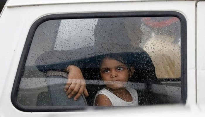 A girl looks out of a car window with raindrops during the seasons first monsoon rain in Karachi on July 6, 2020. — Reuters/File