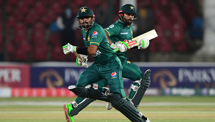 Pakistans captain Babar Azam (L) and his teammate Mohammad Rizwan run between the wickets during the third Twenty20 international cricket match between Pakistan and West Indies at the National Stadium in Karachi on December 16, 2021. — AFP