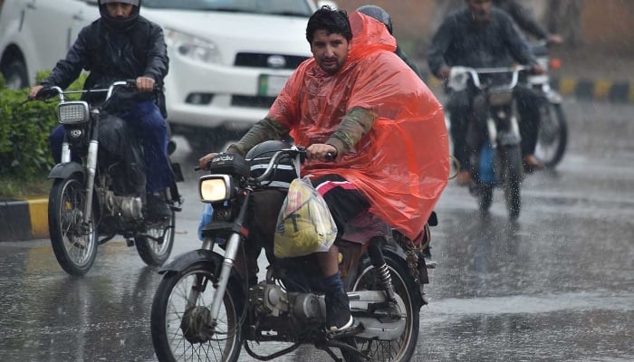 Motorcyclists on the way during rain in Karachi on March 1, 2024. —INP