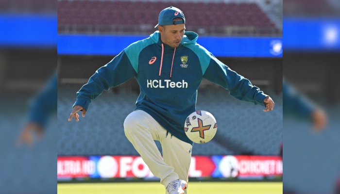 Australia’s Usman Khawaja warms up with a football prior to the start of day three of the first cricket Test match between Australia and West Indies at Adelaide Oval in Adelaide on January 19, 2024. —AFP