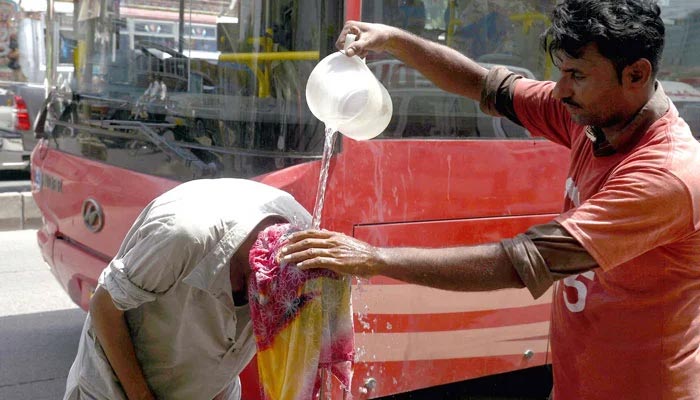 Volunteers of Edhi Foundation cooling commuters with water in Karachi on Friday, June 21, 2024. — PPI