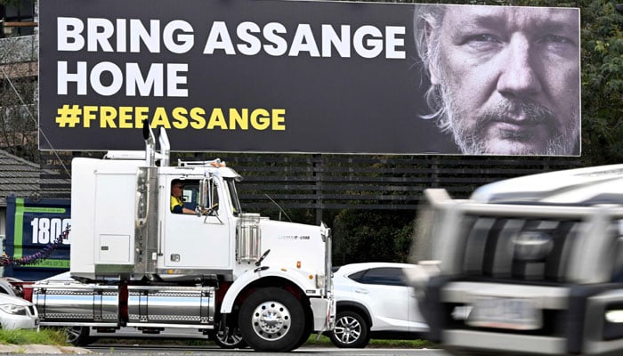 Vehicles drive past a giant billboard calling for the release of WikiLeaks founder Julian Assange in Melbourne on September 5, 2023. — AFP File