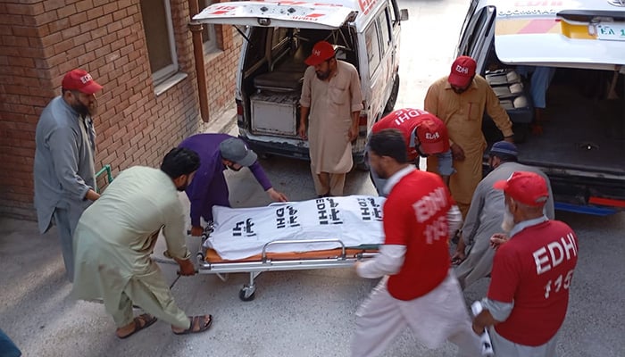 Rescue workers shifting bodies from crime scene where nine of a family killed in gun attack in Peshawars Badaber village on June 25, 2024. — Reporter