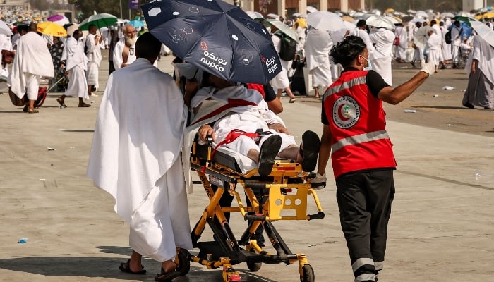 Medical team members evacuate a Muslim pilgrim, affected by the scorching heat, at the base of Mount Arafat, also known as Jabal al-Rahma or Mount of Mercy, during the annual Hajj pilgrimage on June 15, 2024. —AFP