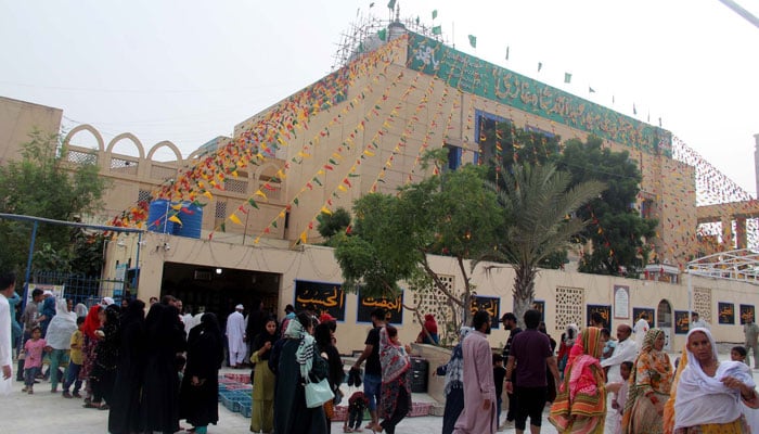 Devotees of Hazrat Abdullah Shah Ghazi gather at his shrine during a pleasant evening on the eve of three days Urs celebrations in Karachi, on Saturday, July, 8, 2023. — PPI