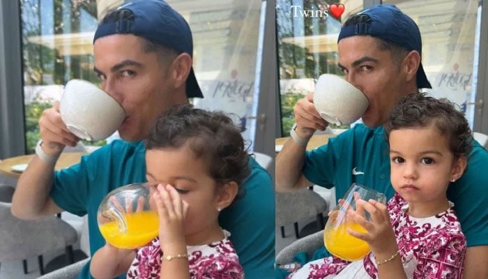 Portuguese player Cristiano Ronaldo drinks tea as his daughter Bella sips juice. — Instagram/@georginagio