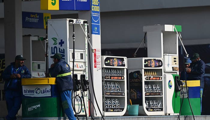 Employees at a fuel station wait for customers in Islamabad on February 16, 2022. — AFP