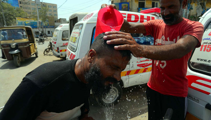 Volunteers of Edhi Foundation watering commuters to beat the heat at Tower area in Karachi on June 28, 2024. — PPI
