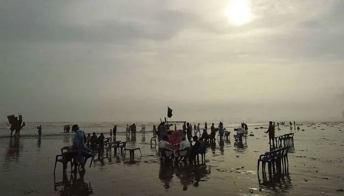 People pictured at Karachis sea view beach on June 16, 2023. — INP