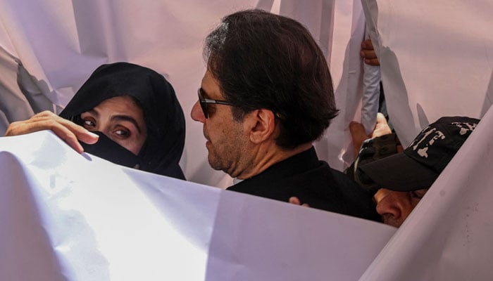 Former Pakistan Prime Minister Imran Khan (C) with his wife Bushra Bibi (L) arrive to appear at a high court in Lahore on May 15, 2023. — AFP File