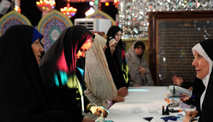 An Iranian woman arrives to cast her vote at Shiite Muslim shrine being used as a polling station, in Tehran on July 5, 2024. — AFP