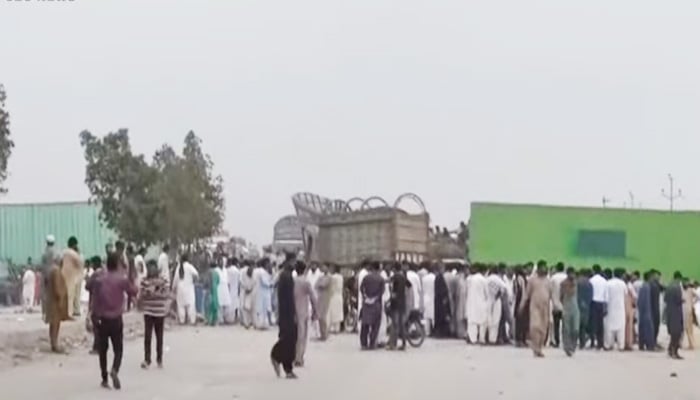 Numerous people gathered at National Highway to stage a sit-in against death of woman. — Screengrab/GeoNews