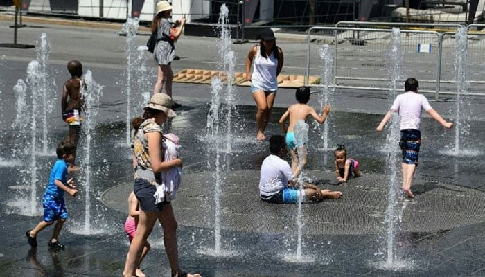 People play in water fountains at the Place des Arts in Montreal during a deadly heatwave. — AFP/File