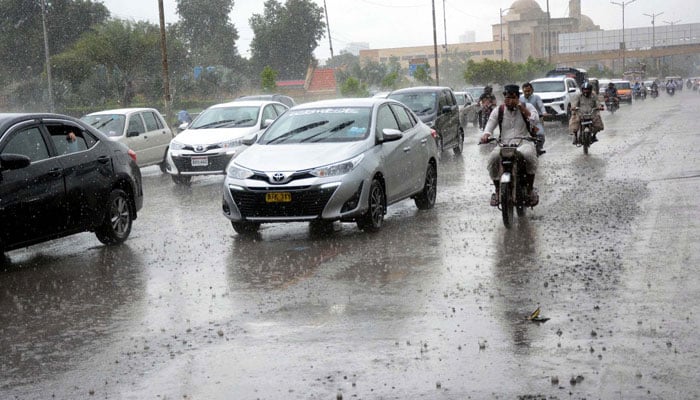 Commuters are passing through a road during heavy downpour of monsoon season, at Shahrah-e-Faisal road in Karachi on Tuesday, July 9, 2024. — PPI