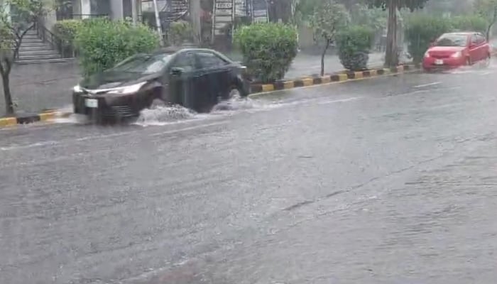 People on their way on a road during heavy monsoon rain in Lahore on July 12, 2024. —Reporter