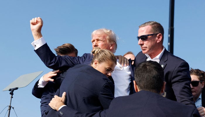 Republican presidential candidate former President Donald Trump is rushed offstage during a rally on July 13, 2024 in Butler, Pennsylvania. — AFP