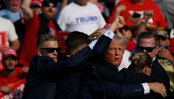 Republican presidential candidate Donald Trump is whisked away by Secret Service after shots rang out at a campaign rally at Butler Farm Show Inc. on July 13, 2024 in Butler, Pennsylvania. — AFP