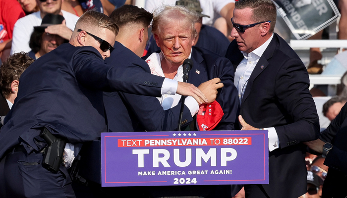 Republican presidential candidate Donald Trump is whisked away by Secret Service after shots rang out at a campaign rally at Butler Farm Show Inc. on July 13, 2024 in Butler, Pennsylvania. — Reuters