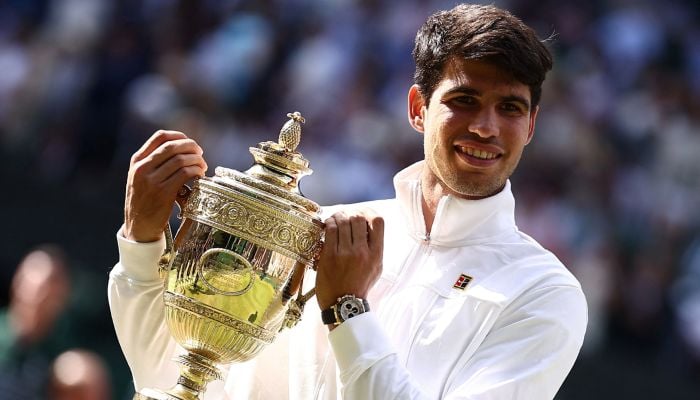 Spains Carlos Alcaraz poses with the winner´s trophy after beating Serbia´s Novak Djokovic during their men´s singles final tennis match on the fourteenth day of the 2024 Wimbledon Championships at The All England Lawn Tennis and Croquet Club in Wimbledon, southwest London, on July 14, 2024. — AFP