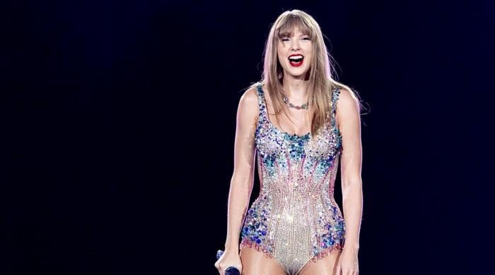 Taylor Swift enjoys snack time on stage during Milan show