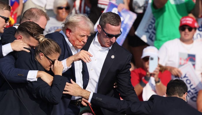 Republican presidential candidate and former US president Donald Trump with his bloodied face is assisted by the Secret Service as multiple shots rang out during a campaign rally at the Butler Farm Show in Butler, Pennsylvania, US, July 13, 2024. — Reuters