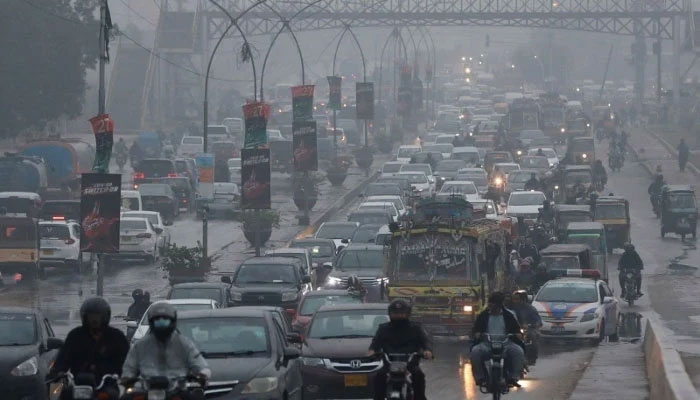 Vehicles move on a road during rainfall in Karachi, Pakistan on Monday, December 27, 2021. — Reuters