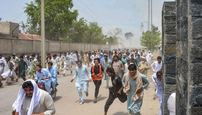 Protesters run as gunfire broke out during a protest rally in Bannu, Khyber Pakhtunkhwa on July 19, 2024. — AFP