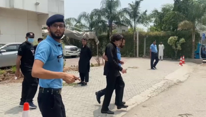 An official of the Islamabad Police is escorting PTI Information Secretary Raoof Hasan in Islamabad on July 22, 2024. — Geo News