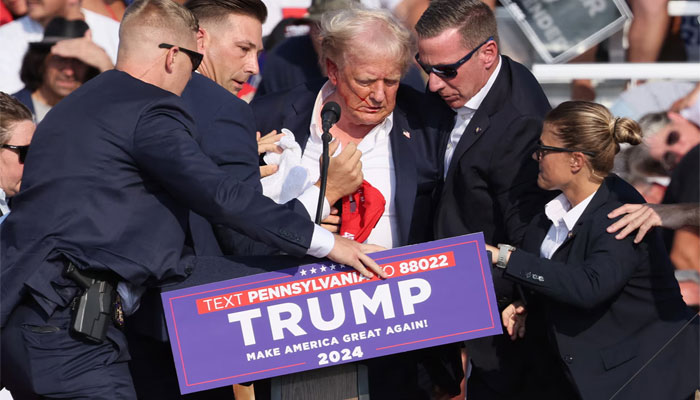 Republican candidate and former president of the United States, Donald Trump is being assisted by security personnel after a bullet grazed his ear during a rally at the Butler Farm Show in Butler, Pennsylvania on July 13 — Reuters