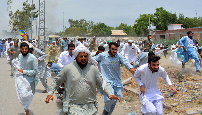 Protesters run as gunfire broke out during a protest rally in Bannu on July 19, 2024. — AFP