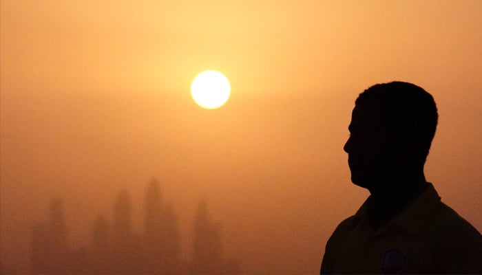 A man is pictured in front of the setting sun during a heatwave in this undated image. — Reuters/File