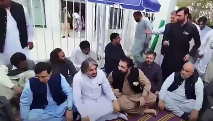 PTI Chairman Barrister Gohar Ali Khan (left) sitting at the hunger strike camp outside Parliament House, Islamabad, alongside other party leaders on July 23, 2024. — Screengrab via Geo News