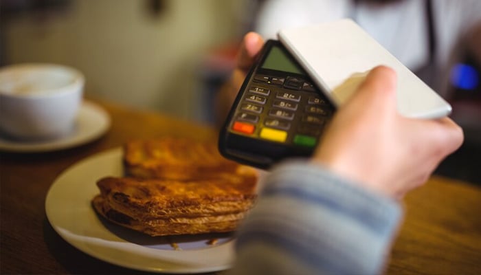 Representational image of a diner making a POS payment at an eatery. —Unsplash