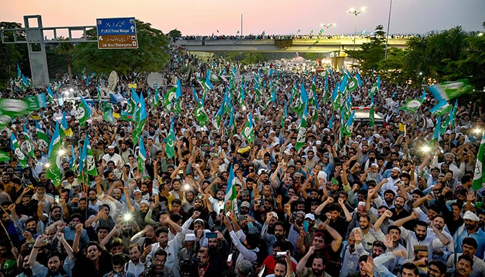 Activists and supporters of Jamaat-e-Islami (JI) shout slogans and wave their party flag to protest against rising inflation in Islamabad on July 26, 2024.