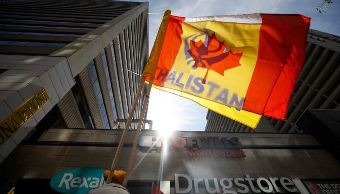 A Canadian flag with the flag of Khalistan can be seen during a Sikh rally outside the Consulate General of India, in Toronto, Ontario, Canada, on September 25, 2023. —AFP