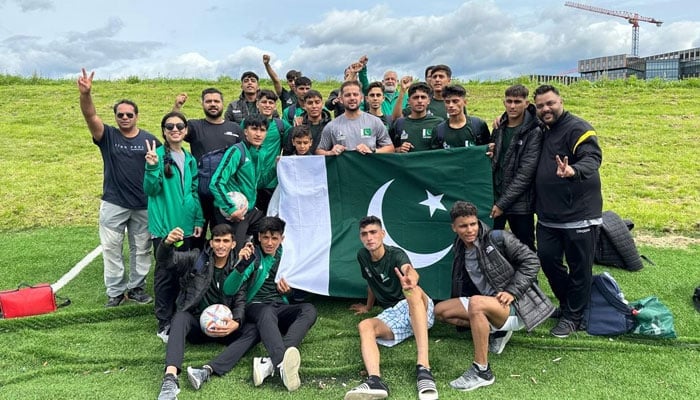 Muslim Hands FC pose with the Pakistani flag after winning their second match in Norway Cup. — Maidaan