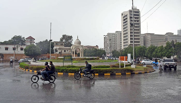 Commuters on their way at Karachi Press Club roundabout during rain in Karachi on July 30, 2024. — Online