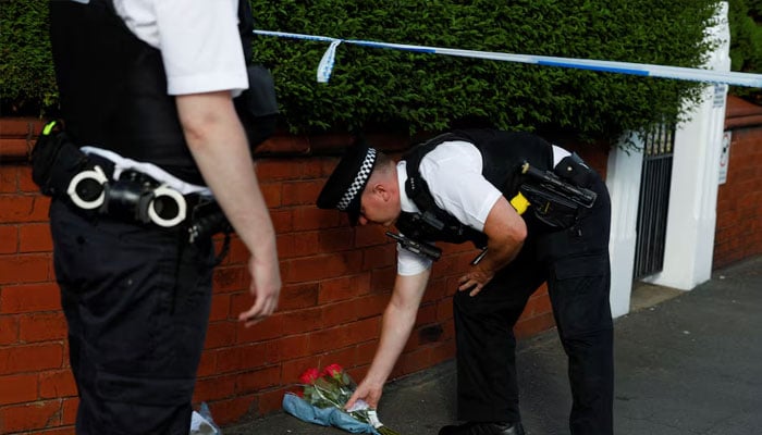 A police officer places flowers, given by residents, behind the police cordon near the scene of a stabbing incident in Southport, Britain, July 29, 2024. — Reuters