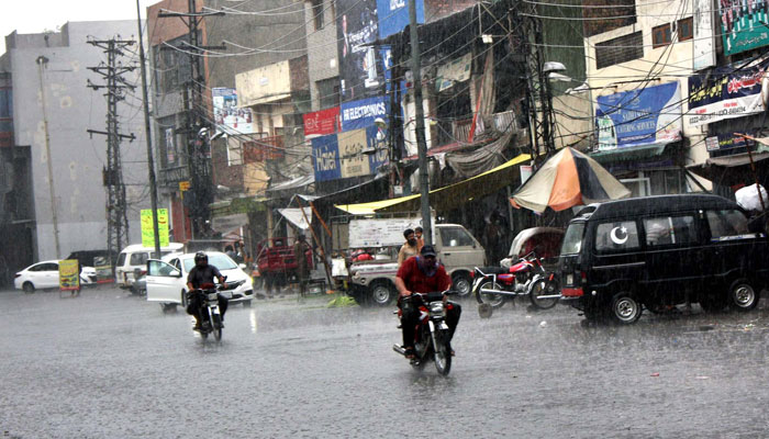 Commuters are passing through a road during heavy downpour of monsoon season, at Multan road in Lahore on Sunday, July 28, 2024. — PPI