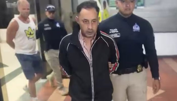 Pazooki Farhad, dubbed The Professor, can be seen escorted by authorites in this still from video released by the Bogota mayors office in Colombia. — X/@josedavid88_