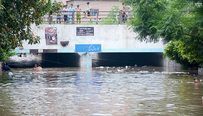 Heavy rains turn the underpass of Du Maurya Bridge in Farooq Ganj into a temporary canal as record-breaking downpours hit Lahore on August 1, 2024. — APP