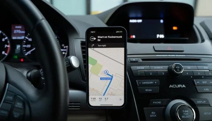 Car dashboard with an apple map open on the phone.— Unsplash