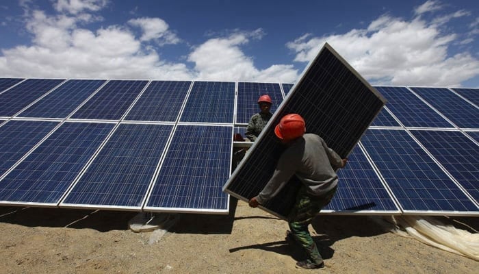 This image shows workers installing a solar panel in Jiuquan, Gansu province in China. — Reuters/File