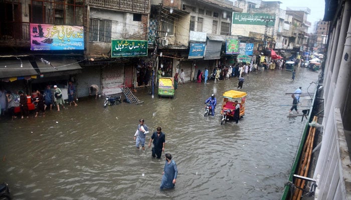 Commuters are seen on a flooded road during heavy monsoon rain in Rawalpindi, Pakistan, on July 29, 2024. — INP