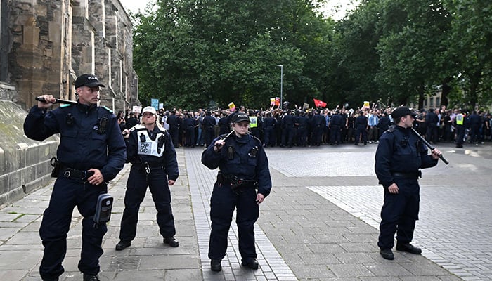 Police officers holding batons stand in front of counter-protesters in Bristol, southern England, on August 3, 2024 against the ´Enough is Enough´ demonstration held in reaction to the fatal stabbings in Southport on July 29. — AFP