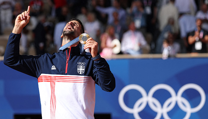 Gold medallist Novak Djokovic of Serbia gestures while holding his medal. — Reuters