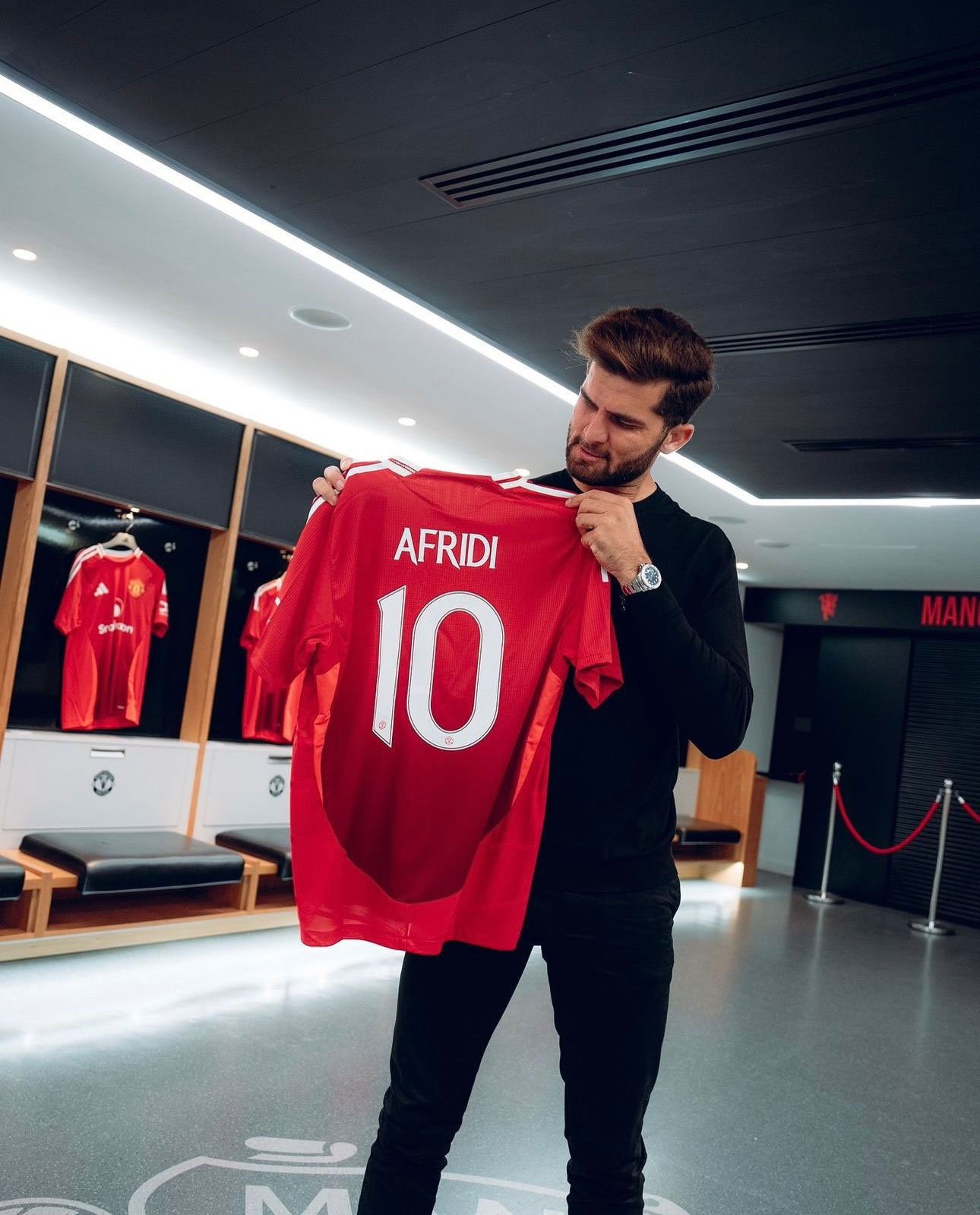 Pakistans cricket star Shaheen Shah Afridi poses with a jersey of Manchester United. — photo provided by reporters