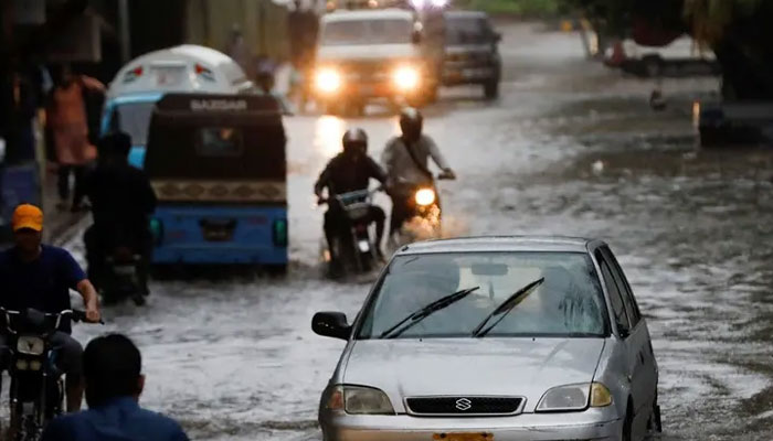 Residents commute through a flooded street during the monsoon season in Karachi, Pakistan. — Reuters/File