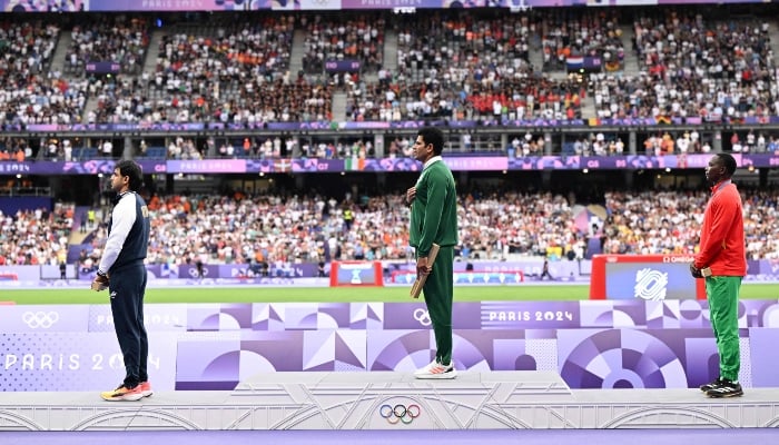 (L-R) Silver medallist Indias Neeraj Chopra, gold medallist Pakistans Arshad Nadeem and bronze medallist Grenadas Anderson Peters celebrate on the podium during the victory ceremony for the mens javelin throw athletics event during the Paris 2024 Olympic Games at Stade de France in Saint-Denis, Paris, on August 9, 2024. —AFP